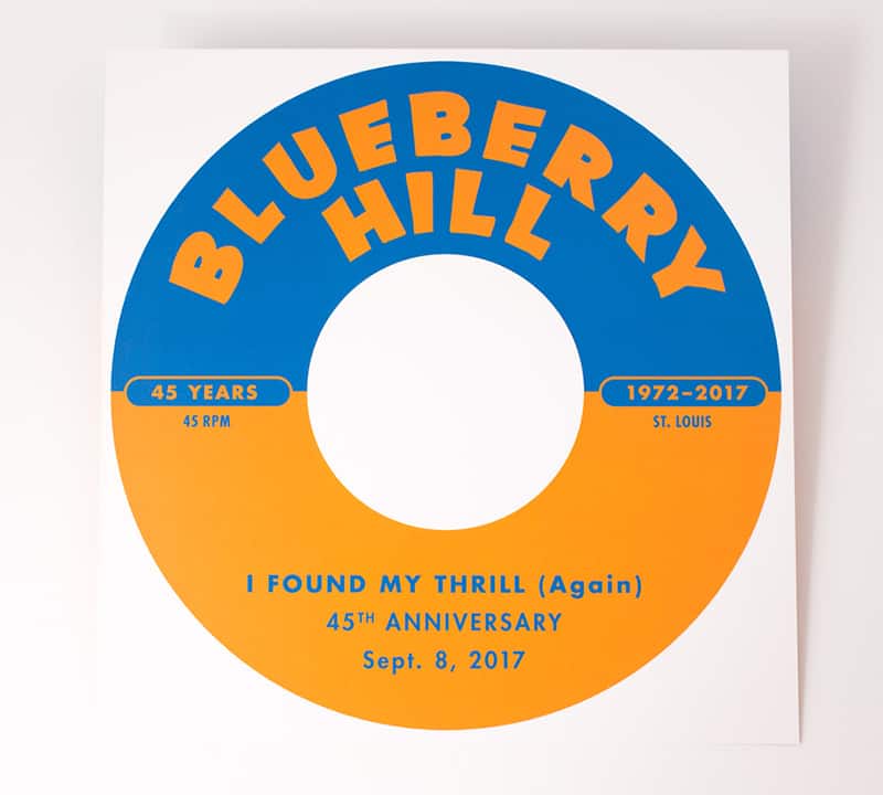 Blue and hot orange invitation to Blueberry Hill's 45th Anniversary Party. The graphic looks like the label of an old 45rpm record. Blueberry Hill is in orange on blue on the top half and the information about the party is on the bottom half in blue ink on top of orange.