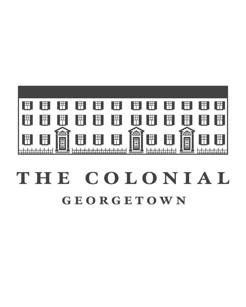 A charcoal gray logo on charcoal on a white background featuring a line drawing of a Colonial-style historic building with three doors and many windows. In elegant serif type it says "The Colonial Georgetown".